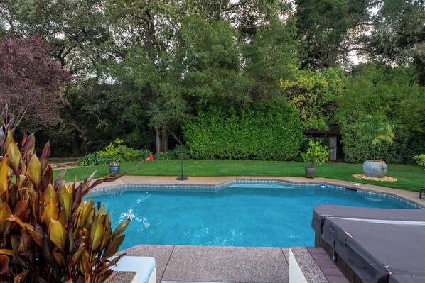 A swimming pool with a surrounding garden and a covered seating area. - Blossom Villa-pool+sanctuary+ minutes to wineries (Sonoma)