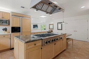 A modern kitchen with a central island, built-in appliances, and a large window providing natural light. - Blossom Villa-pool+sanctuary+ minutes to wineries (Sonoma)