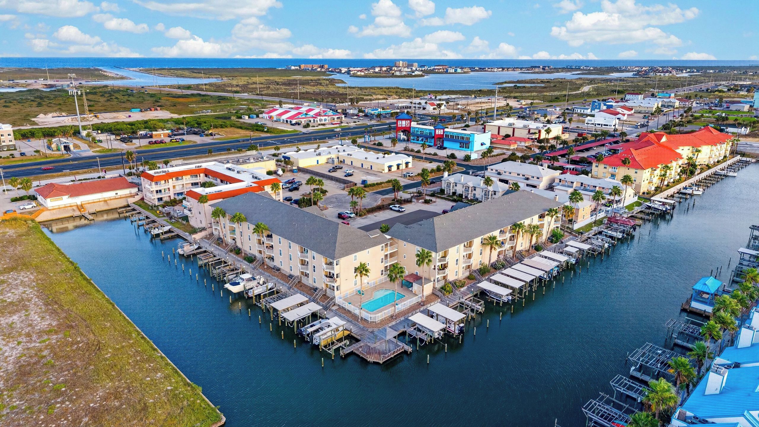 A marina with docked boats, a swimming pool, and a waterfront building.