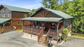 Eine Holzhütte mit Veranda, überdachter Terrasse und Steinfundament.