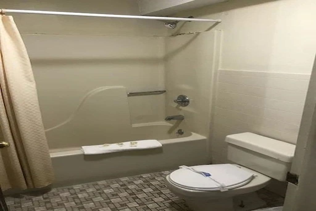 Ein kleines Badezimmer mit Badewanne, Toilette und Duschvorhang.