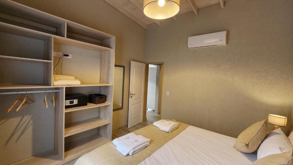 Una habitación de hotel con cama, armario, espejo y puerta que da a otra habitación.