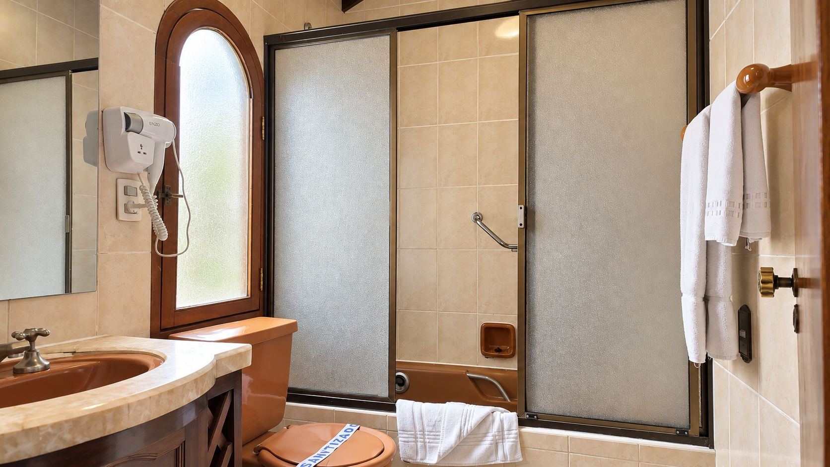 A bathroom with a sink, mirror, and a shower with a glass door.