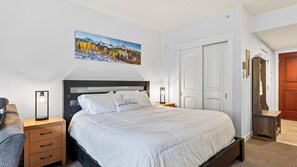A bedroom with a bed, bedside tables, a nightstand, a painting, and a wardrobe. - Little Moose by Avantstay Steps To Winter Park Gondola Shared Hot Tub + Pool (Winter Park)