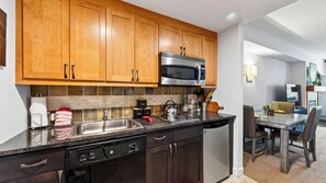 A modern kitchen with wooden cabinets, a stainless steel microwave, and a dishwasher. - Little Moose by Avantstay Steps To Winter Park Gondola Shared Hot Tub + Pool (Winter Park)