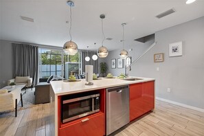 A modern kitchen with a central island, built-in appliances, and pendant lighting. - Magical 4BR Home Mickey & Star Wars Rooms Pool (Kissimmee)