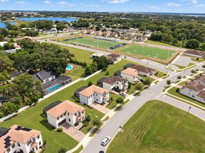 A residential area with houses, a swimming pool, and a sports field. - Resort Water Park, 20 Min to LEGOLAND (Haines City)