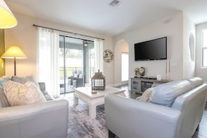 A living room with a sofa, a coffee table, a flat-screen TV, and a fireplace. - Resort Water Park, 20 Min to LEGOLAND (Haines City)