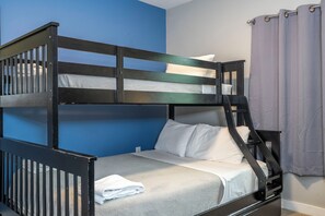 A bunk bed with a grey mattress and white pillows, a blue wall, and a grey curtain. - 4BR Private Pool Near Disney & Supermarkets (Kissimmee)