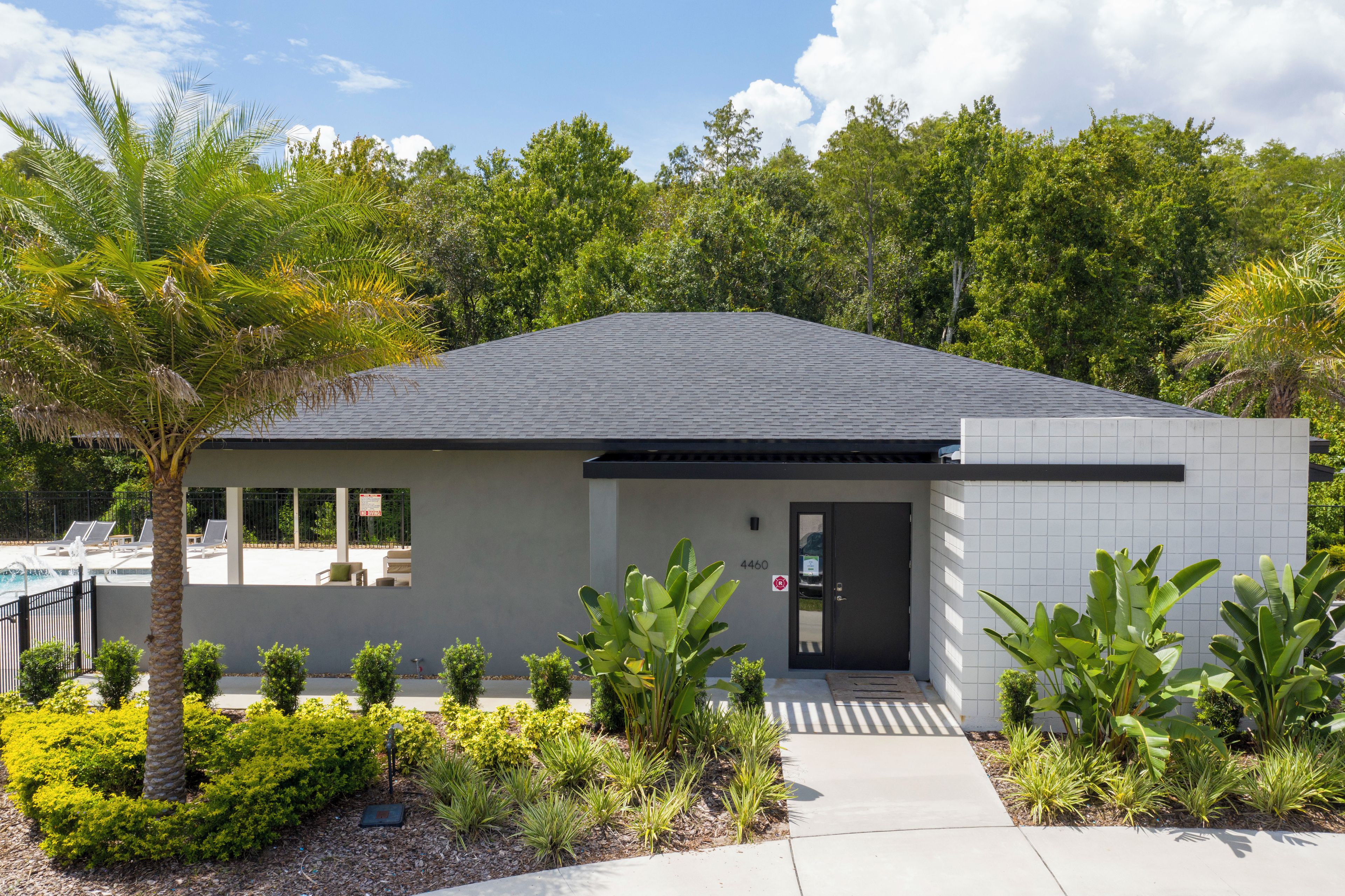A modern building with a flat roof, a door, and a small window.