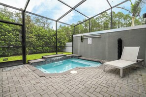 An indoor swimming pool with a glass enclosure, a lounge chair, and a pool rules sign. - 4BR Private Pool Near Disney & Supermarkets (Kissimmee)