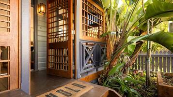 A wooden entrance with a door, a small porch, and a welcome mat.