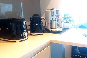 Een aanrecht met een broodrooster, een koffiezetapparaat en een waterkoker.