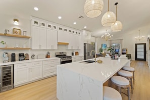 A modern kitchen with white cabinetry, a marble island, stainless steel appliances, and pendant lighting. - Private Waterfront resort. FREE heated pool, Jacuzzi. Boat, Sauna. Ocotillo (Chandler)