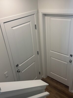 Une porte blanche dotée d’une poignée et d’un trou de serrure, située à côté d’une autre porte blanche au design similaire.