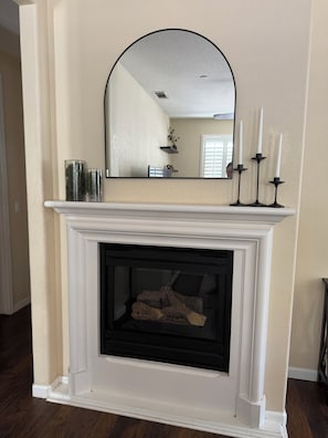 A fireplace with a white mantel, a mirror above it, and three candles. - Windham Retreat (Chico)