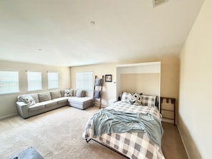 A bedroom with a large bed, a sofa, and a ladder against the wall. - Windham Retreat (Chico)