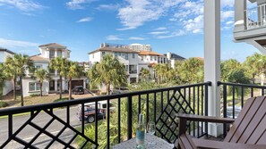 A balcony with a view of a residential area, including houses and palm trees. - Sea E O by Avantstay Sleeps 24 Private Pool + Elevator Gulf Views + Steps to the Beach (Destin)