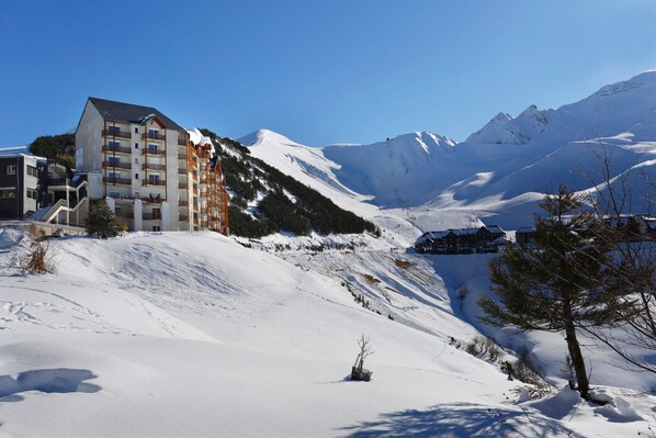 Ein schneebedeckter Berg mit einem Skigebiet und einem mehrstöckigen Hotel.