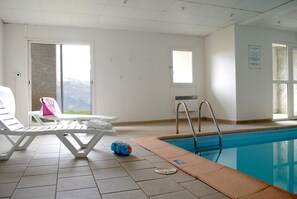 A swimming pool area with lounge chairs and a view of mountains. - Studio Vue Pyrénées | Piscine Chauffée | Sauna (Germ)