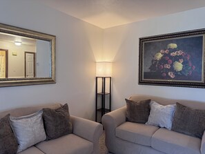 A room with two sofas, a lamp, and a framed floral painting on the wall. - Betty's in Berrien Springs Near AU Newly Renovated (Berrien Springs)