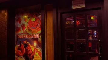 A restaurant interior with a wooden floor, a red lantern, and a sign indicating it's open at 12 noon.