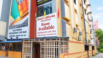 A hotel with a large advertisement for a restaurant and a sign indicating rooms are available.