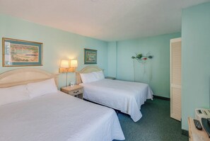 A hotel room with two beds, a nightstand with lamps, and a wall with framed artwork. - Large 1BR unit  with Balcony at Caravelle Tower (Myrtle Beach)