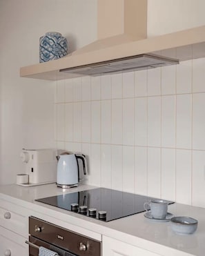 A modern kitchen with a built-in stove, a kettle, and a coffee maker. - Lõco Píso House Pet friendly - Pool & Spa (Brisbane)