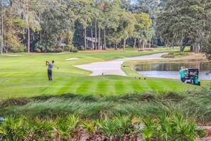 Ein Golfplatz mit Wasserhindernis, Sandbunkern und einem Putting Green.