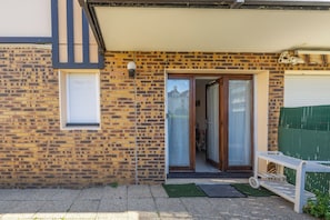A brick house with a front door, a small window, and a green fence. - The Marine Apartment with Terrace & Garden - Welkeys (Villers-sur-Mer)
