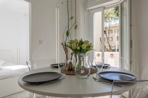 A dining table with plates, cutlery, and a vase with flowers. - La Perle du Mourillon 5 minutes from the beach - Welkeys (Toulon)