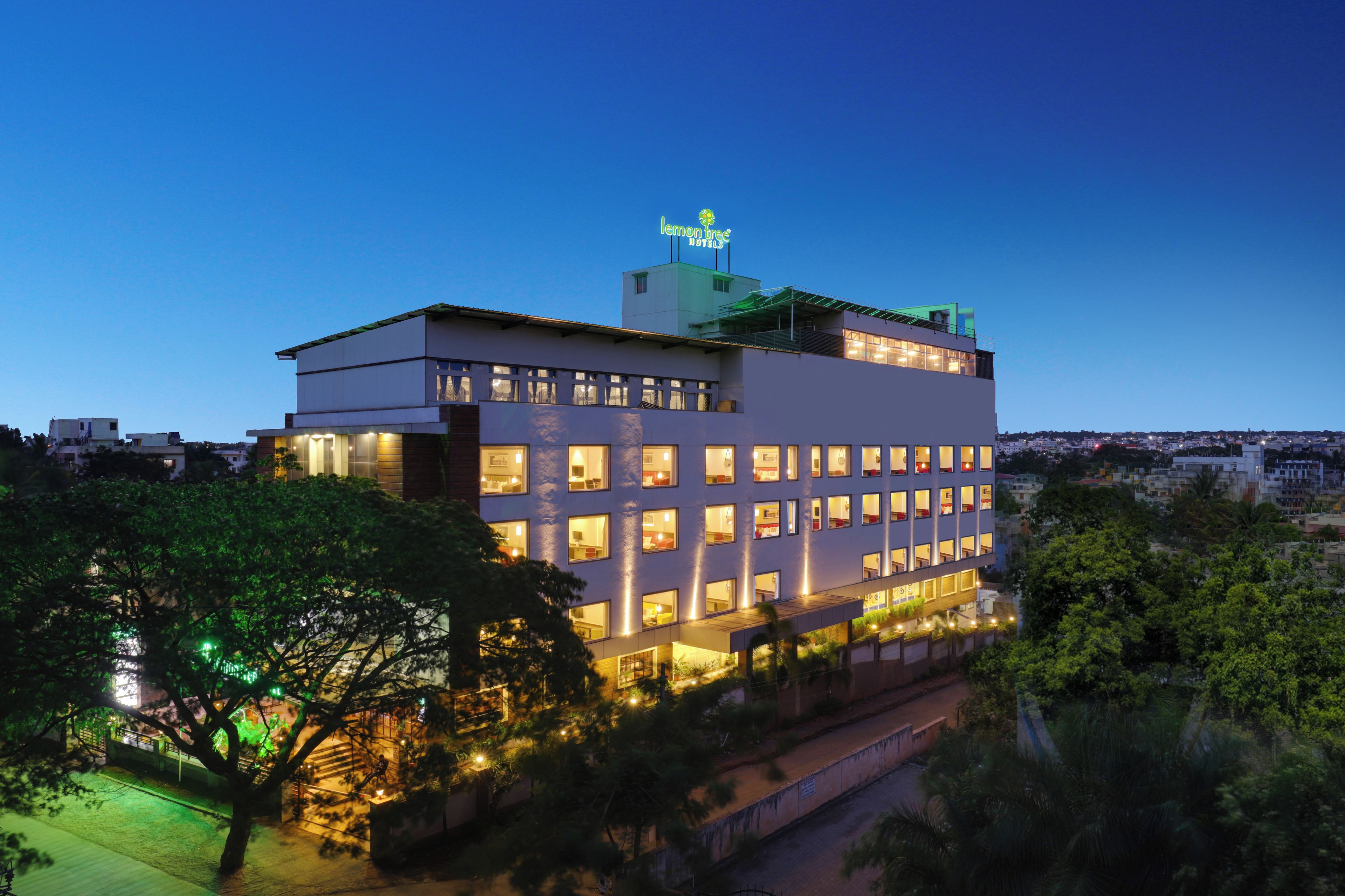 Un hotel de varios pisos con ventanas iluminadas y un letrero en la azotea.