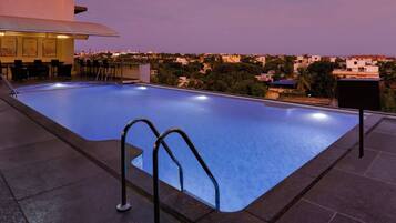 Ein Pool auf dem Dach mit Blick auf die Abendstadt.