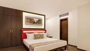 Un dormitorio moderno con una cama grande, un armario de madera y un cuadro en la pared.