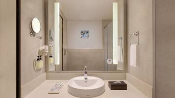 Un baño moderno con un lavabo redondo, un espejo grande y un cabezal de ducha de mano.