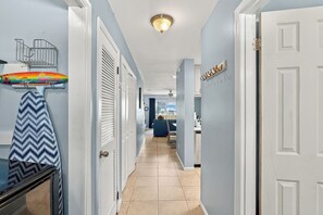 A hallway with white doors, a ceiling light, and a blue wall. - Summer Place 127 | Sleeps 6 | Great Fall Break Vacation! (Panama City)