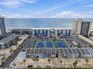 A coastal hotel with multiple buildings, a parking lot, and a tennis court. - Summer Place 127 | Sleeps 6 | Great Fall Break Vacation! (Panama City)