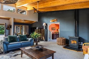 Ein modernes Wohnzimmer mit Kamin, Ledersofa und Essbereich.