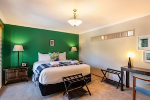 Ein Schlafzimmer mit Bett, Nachttischlampen, Schreibtisch und Stuhl.