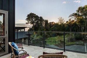 Ein Balkon mit Blick auf einen Garten und eine ferne Landschaft.