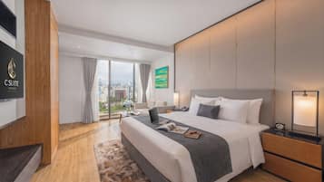 Habitación de hotel moderna con una cama grande, un escritorio, una computadora portátil y vistas a la ciudad.