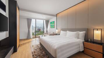 Een moderne hotelkamer met een groot bed, een bureau, een televisie en uitzicht op de stad.