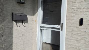 A door with a glass panel, a mailbox, and a welcome mat.