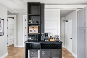 Eine Küche mit integriertem Mikrowellenherd, Kaffeemaschine, Toaster und kleinem Kühlschrank.