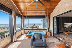 Een moderne woonkamer met uitzicht op de stad, een schommel en een open haard.