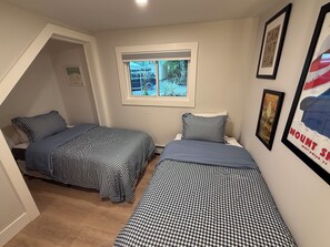 A bedroom with two beds, a window, and framed pictures on the wall. - Tree top views, 1 mile to Mt Snow, spacious getaway , family & pet friendly (Dover)