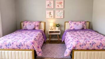 Een slaapkamer met twee bedden, een nachtkastje en wanddecoratie.