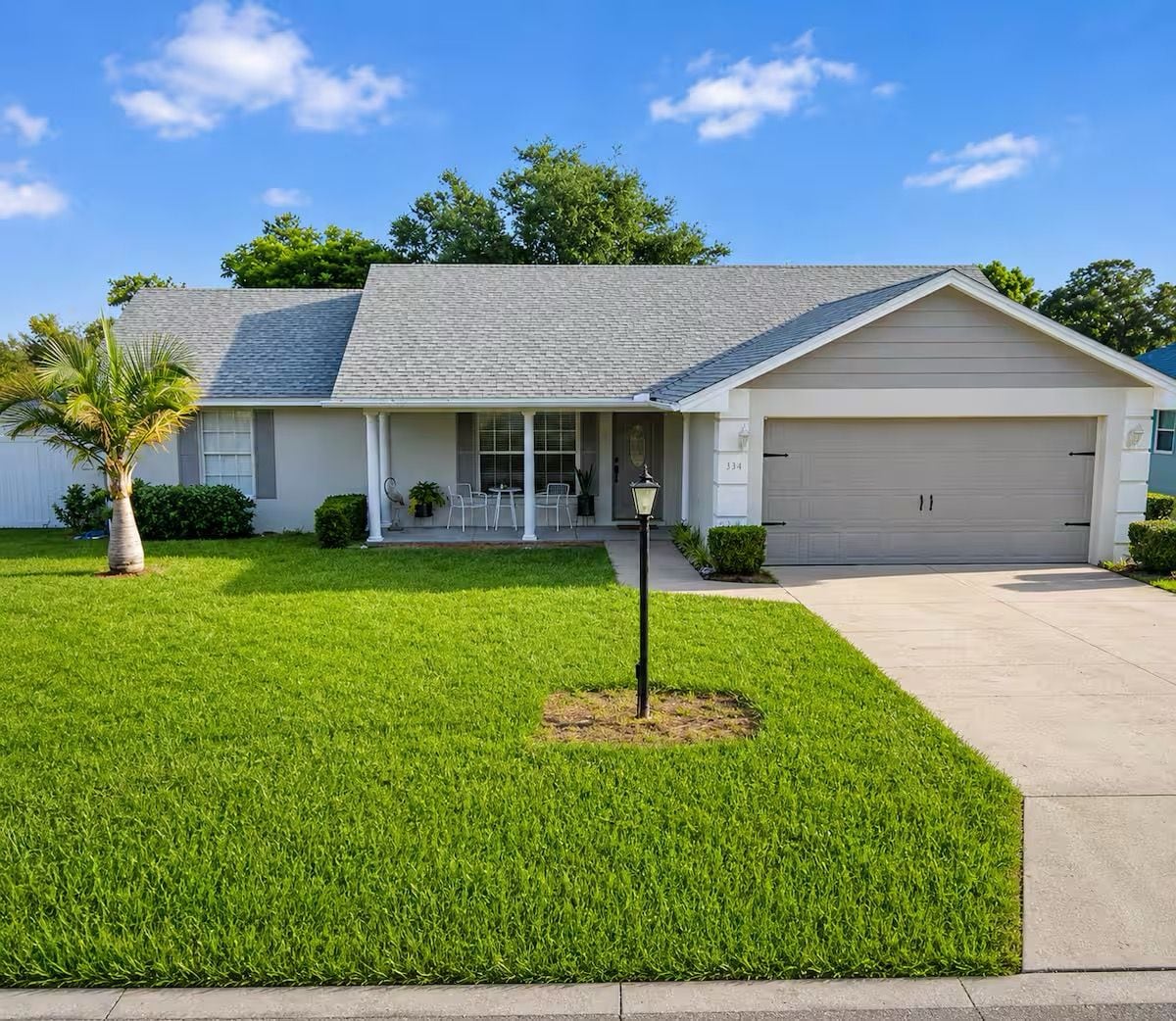 A single-story house with a garage, a front porch, and a well-maintained lawn.