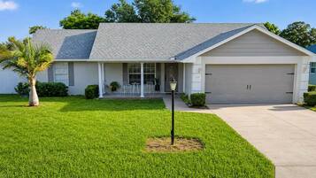 A single-story house with a garage, a front porch, and a well-maintained lawn.